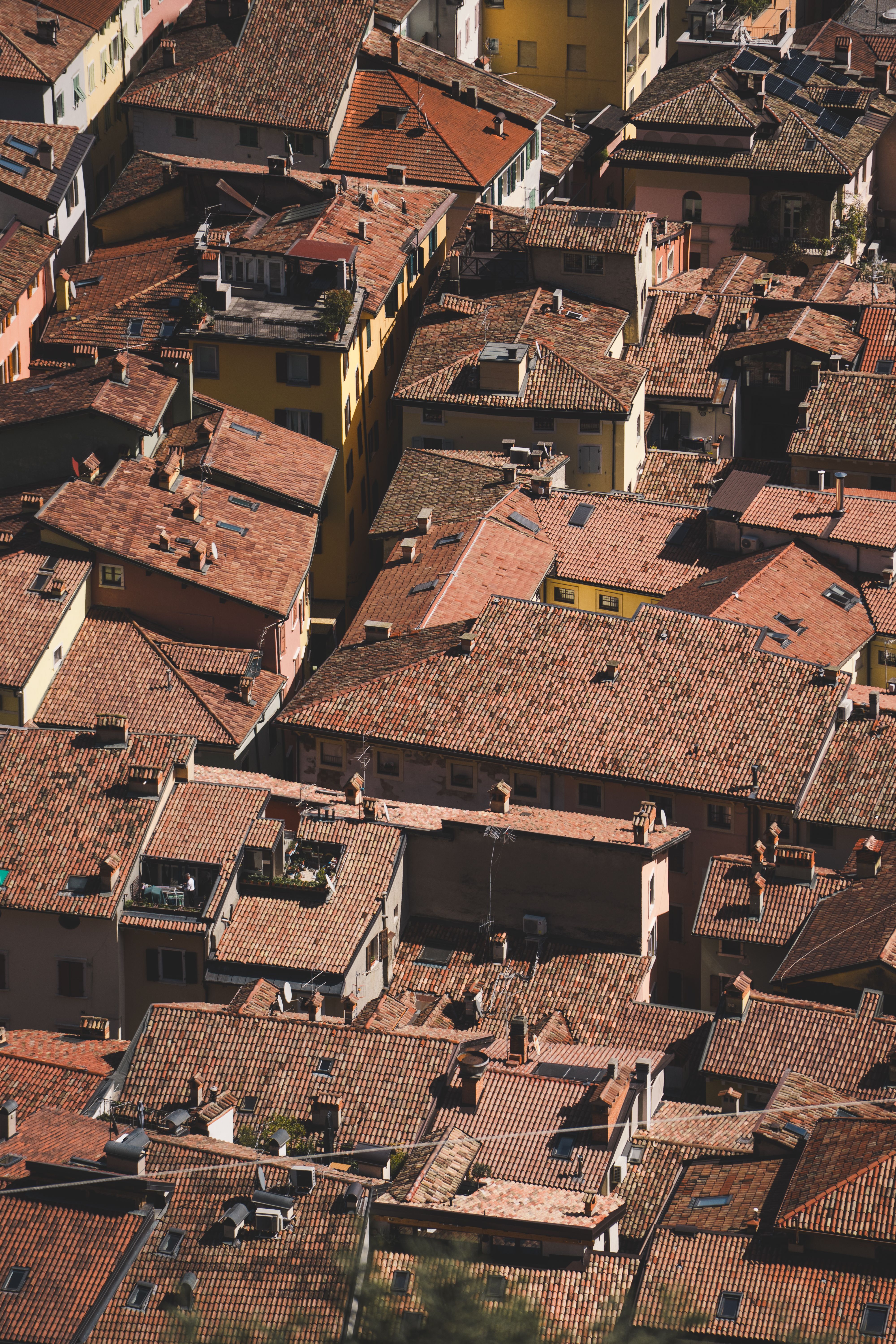 Aerial shot of densely packed traditional European rooftops with warm terracotta tiles.
