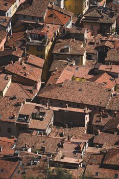 Aerial shot of densely packed traditional European rooftops with warm terracotta tiles.