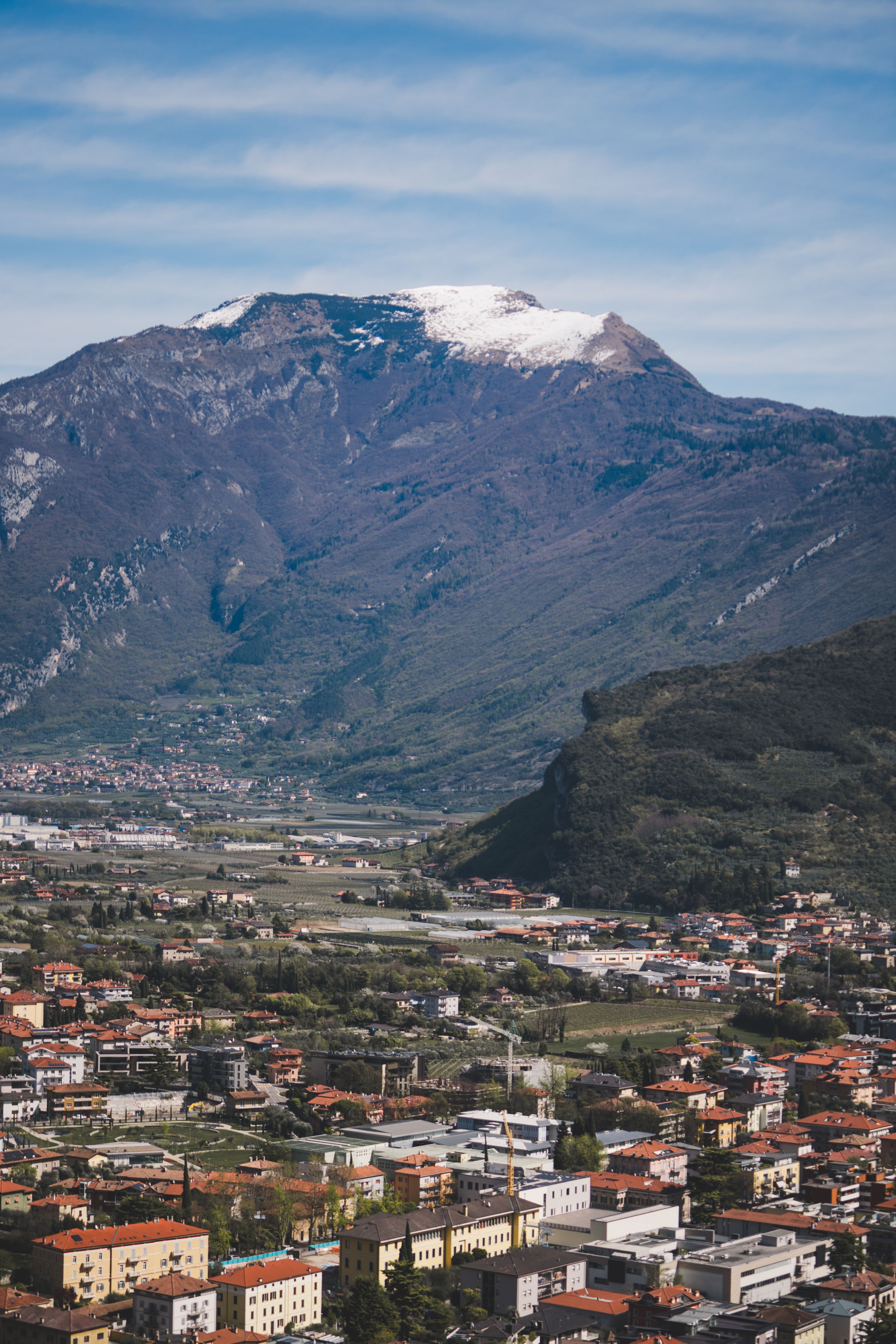 Captivating aerial view of an Italian town with majestic mountains and clear sky.