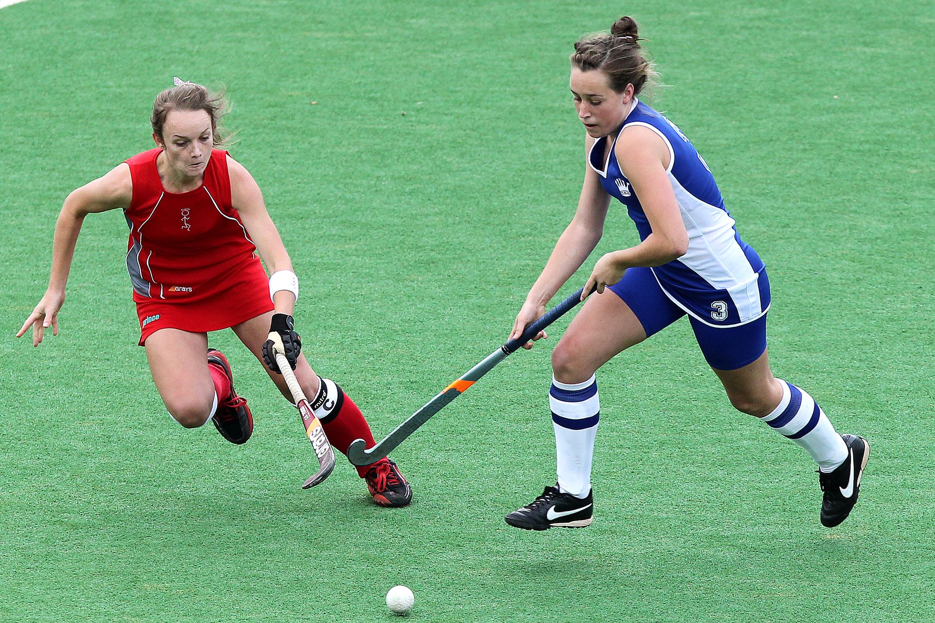 Two players competing for possession in a small-sided drill, with one shielding the ball near the sideline