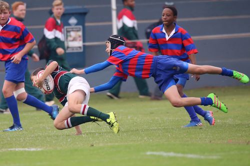 Free Young athletes engaged in a dynamic rugby match, showcasing teamwork and sport. Stock Photo
