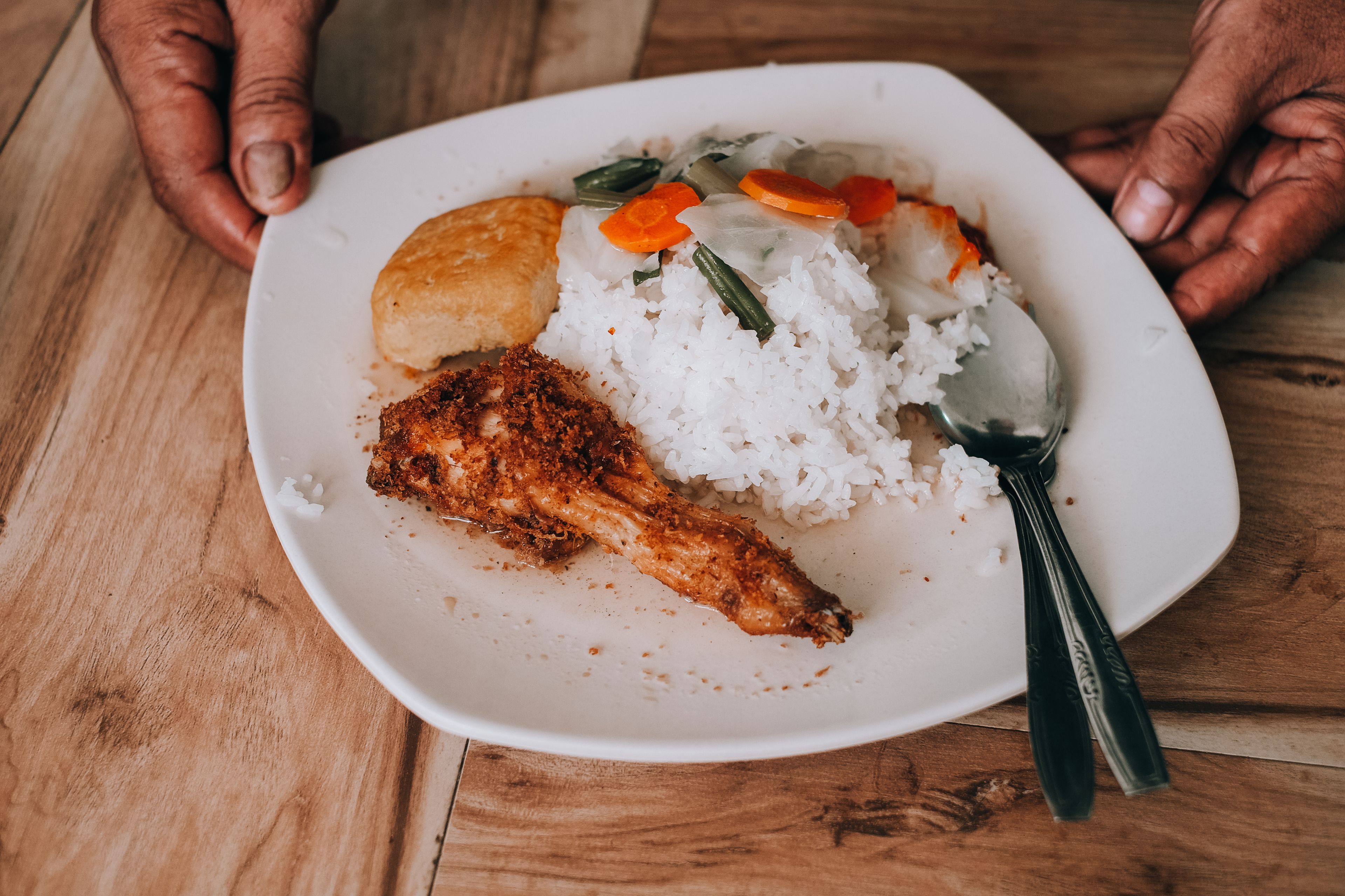 Hearty meal with grilled chicken, rice, and vegetables served on a white plate.