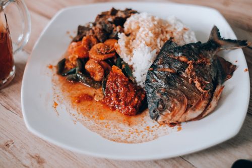 Free Delicious plate of Nasi Campur with fried fish, rice, shrimp, and sambal. Stock Photo