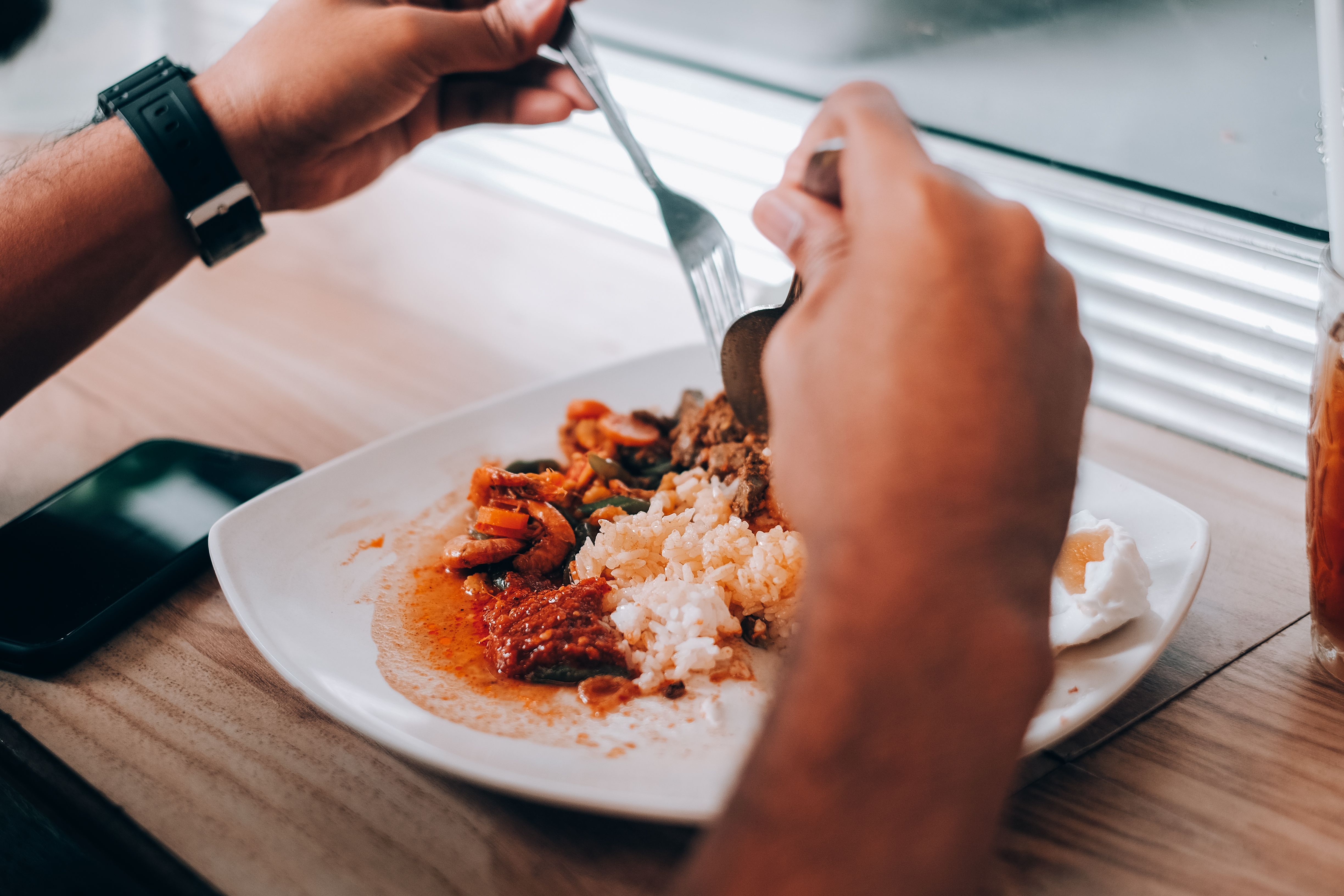 someone eating a meal with both hands, looking at the food, no distractions nearby