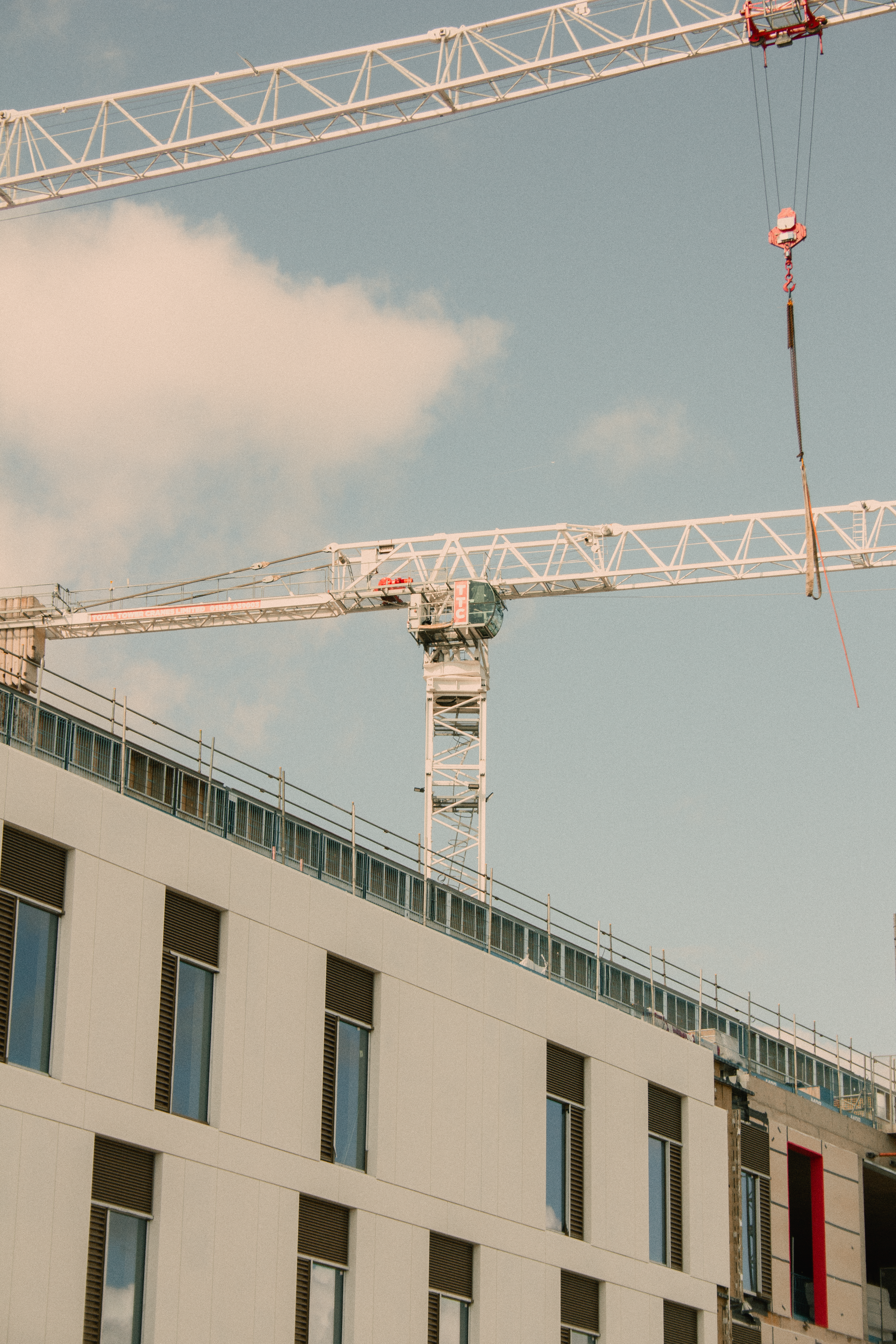 A contemporary construction site in Shrewsbury, England featuring cranes against a clear sky.