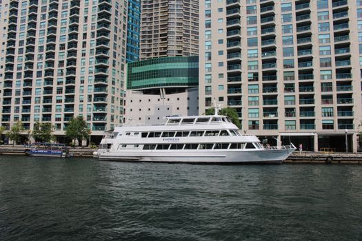 A luxury yacht named 'Empress' docked against skyscrapers in Toronto, showcasing urban waterfront living.