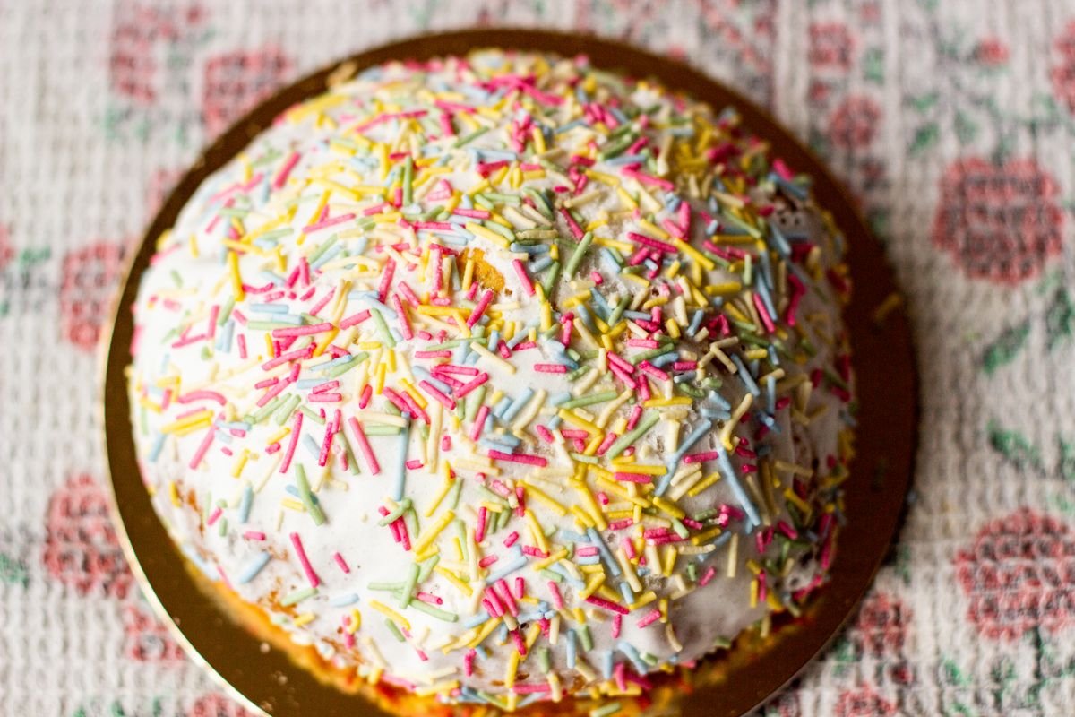 Close-up of a sprinkle-covered celebration cake being filmed — photo by Natalia Sevruk on Pexels