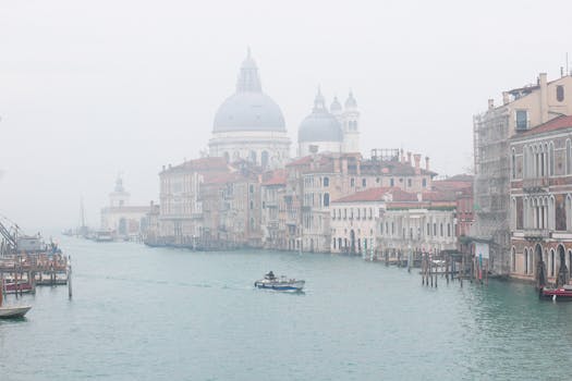 威尼斯大运河的雾景，凸显了其标志性的历史建筑与宁静的水域