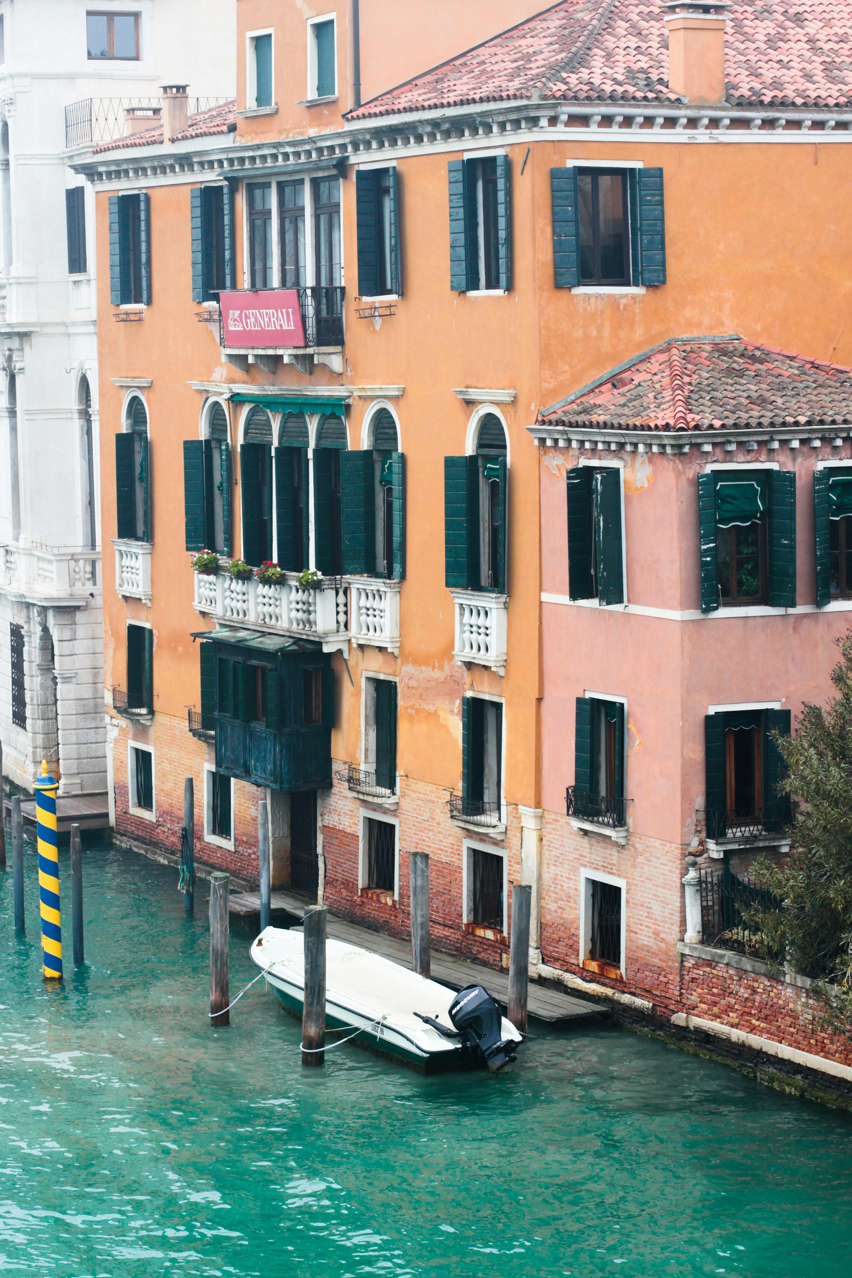 a docked boat on river near buildings