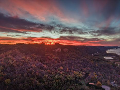 A captivating aerial view of a vibrant sunset over the forested hills of Nelson, Wisconsin.