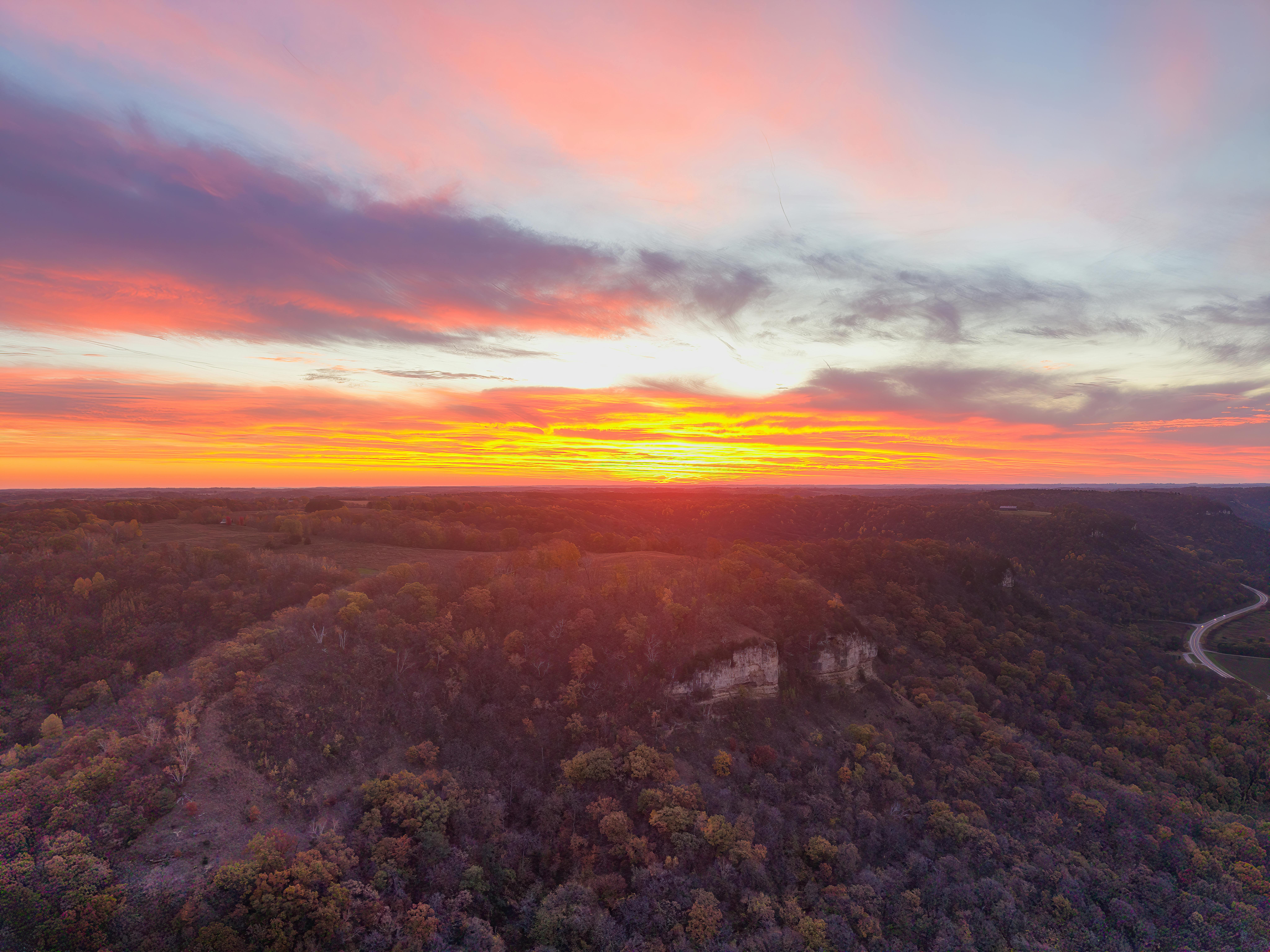 Aerial view of a vibrant sunset over the scenic hills and autumn foliage of Nelson, Wisconsin.