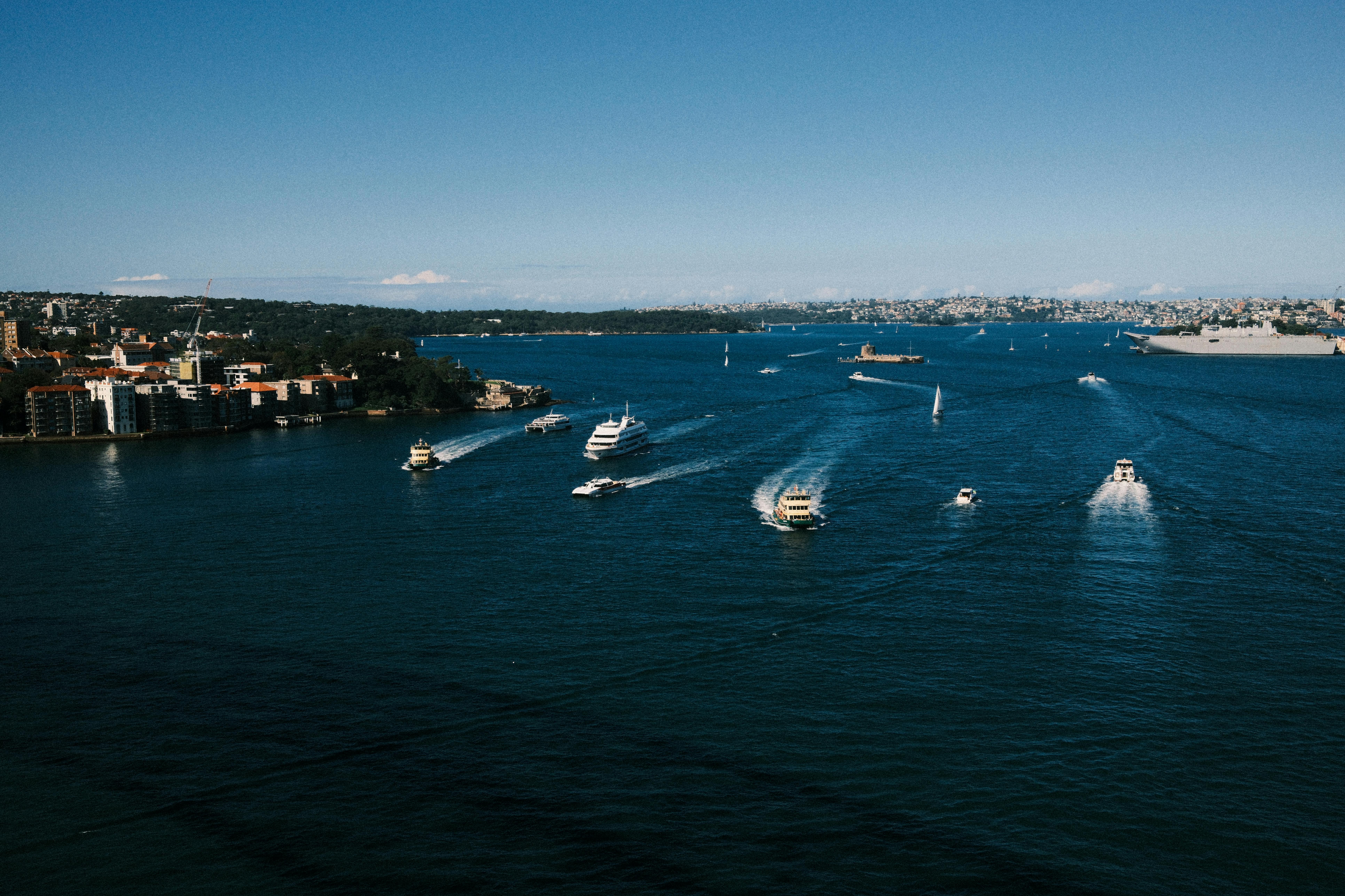 Boats moving across Sydney Harbour on a bright day