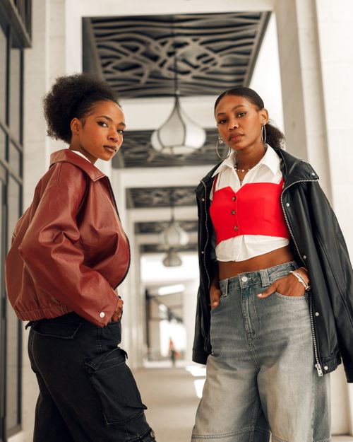 Free Stylish young women pose confidently in urban setting, showcasing modern fashion. Stock Photo