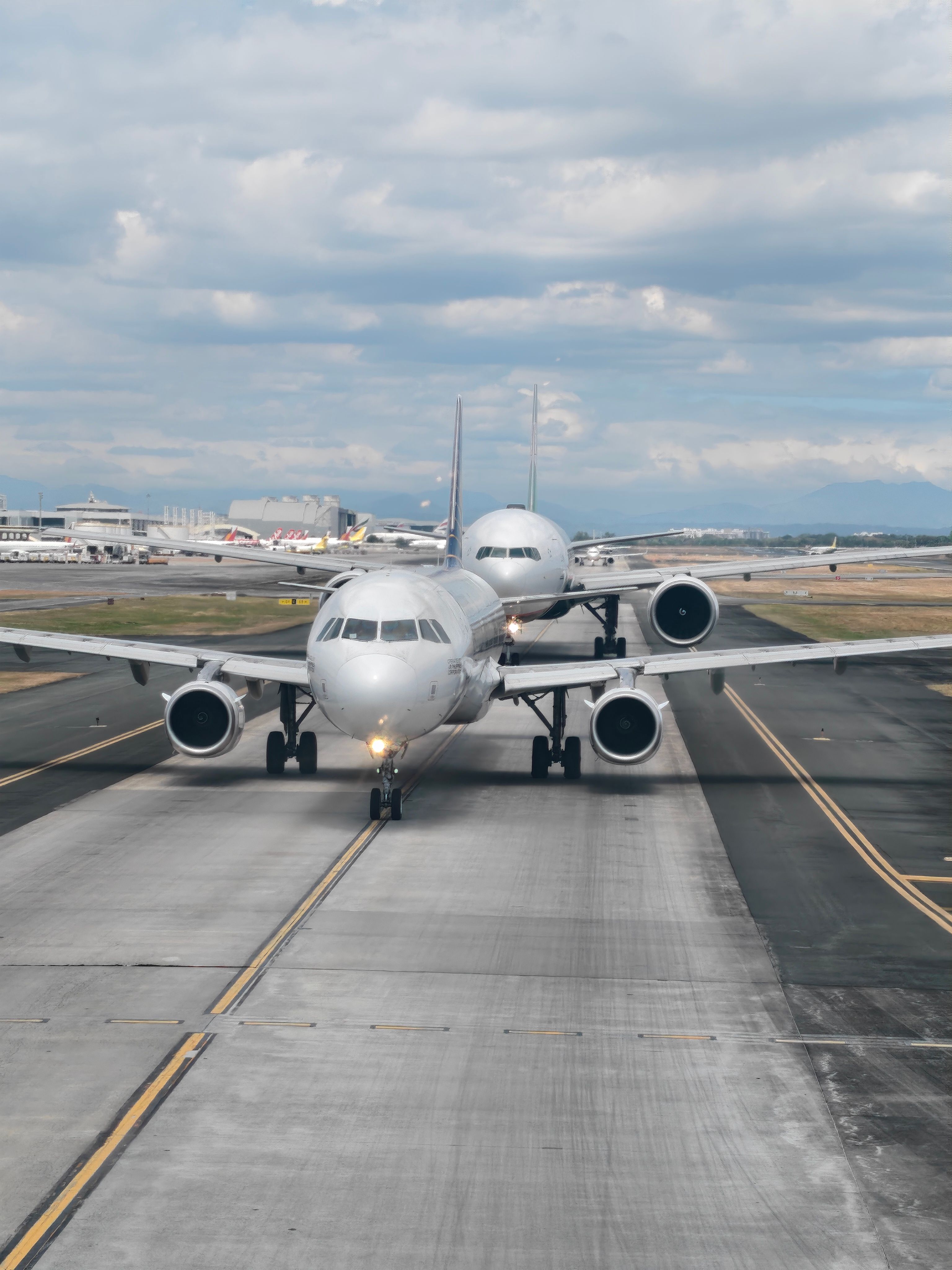 Multiple Boeing and Airbus commercial aircraft parked at airport gates.