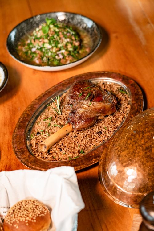Free Lamb shank on spiced rice garnished with rosemary for a flavorful meal. Stock Photo
