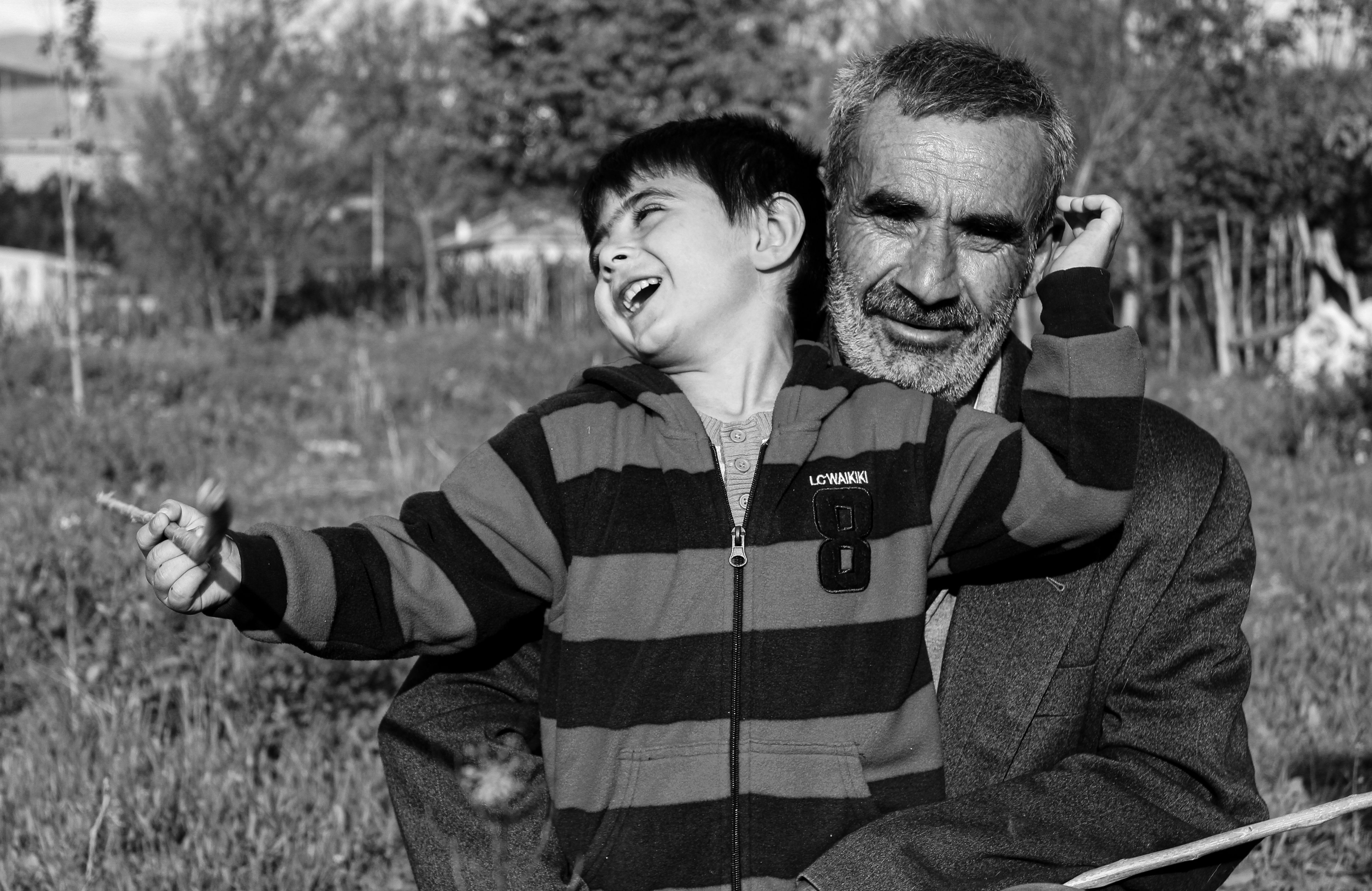 Abuelo Y Nieto Compartiendo Risas Al Aire Libre · Foto de stock gratuita
