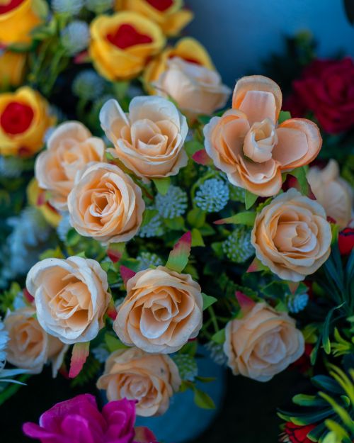 Free A colorful bouquet of lifelike artificial roses in various hues, perfect for home decor. Stock Photo