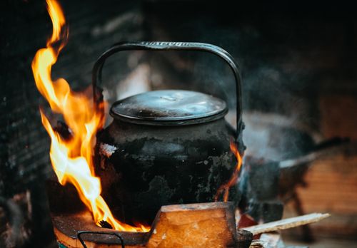 Free A rustic kettle with fire and smoke, depicting traditional Vietnamese cooking outdoors. Stock Photo