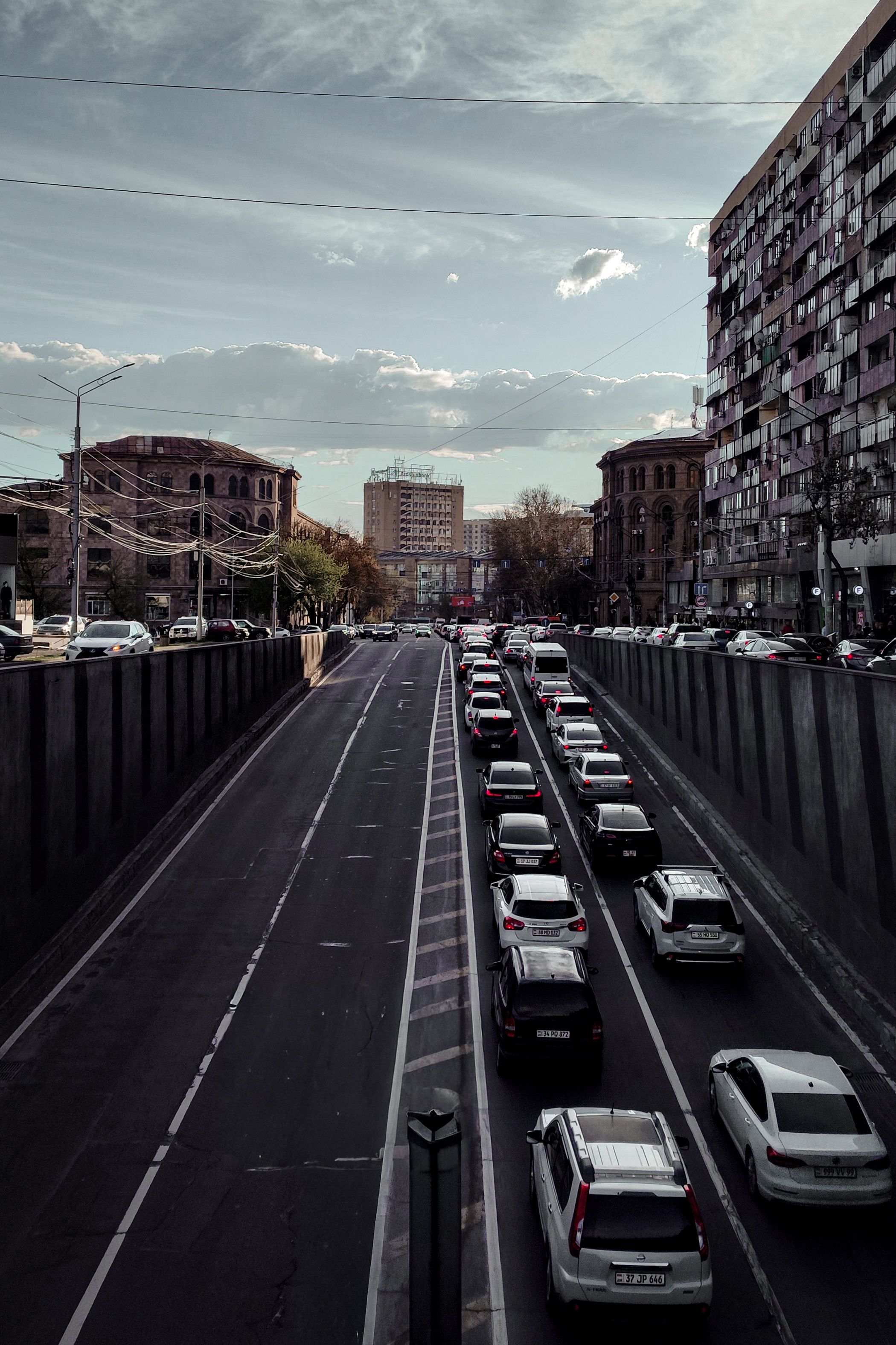 View of a bustling city street with heavy traffic during sunset, showcasing urban architecture.