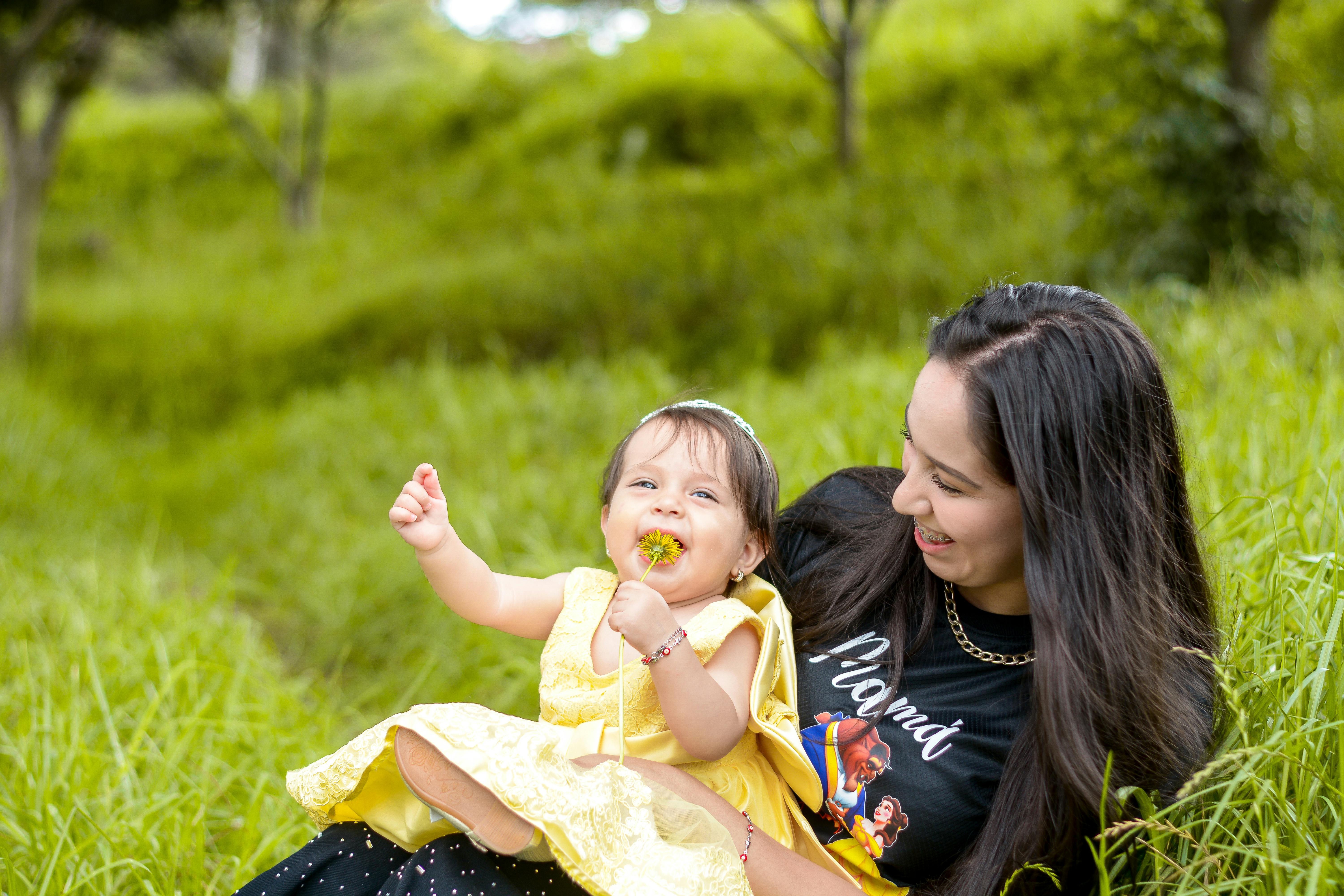 A joyful moment shared between a mother and her baby in a lush green field in Loja, Ecuador.