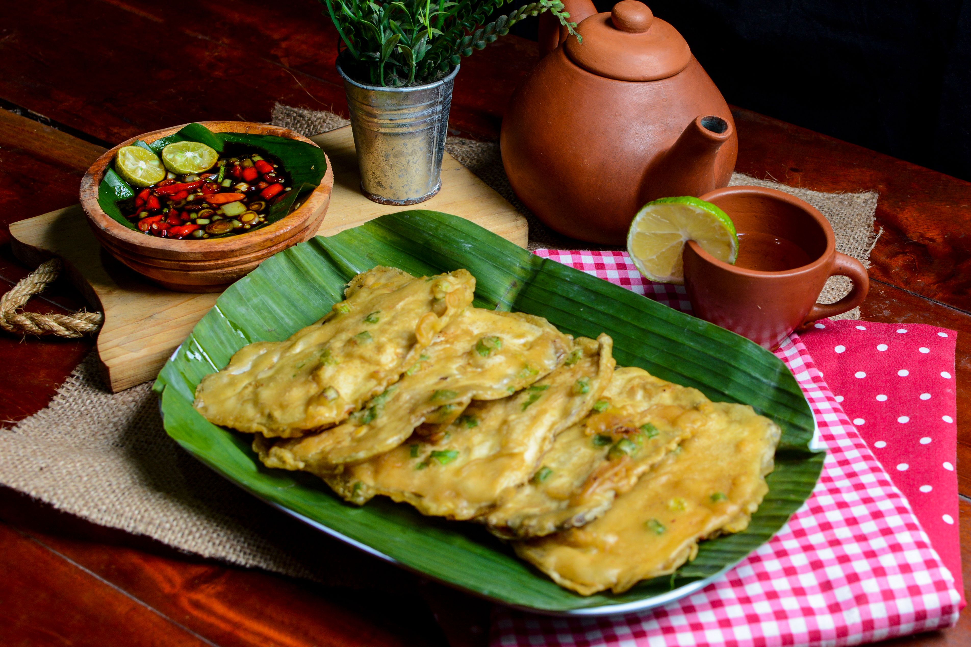 Mendoan served with sambal and tea on a rustic table in Bandung.