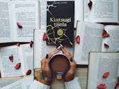 一本书、一杯咖啡和散落的玫瑰花瓣，构成一个宁静的场景，非常适合放松的主题