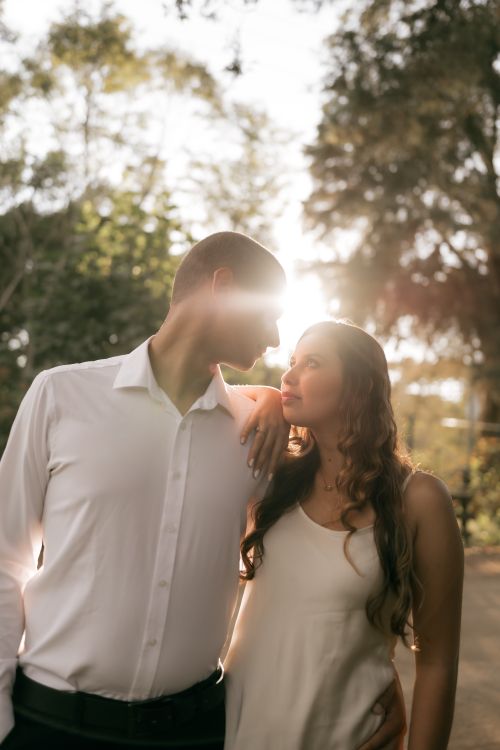 Free A couple in love embraces in a sunlit forest, capturing a moment of intimacy and nature. Stock Photo