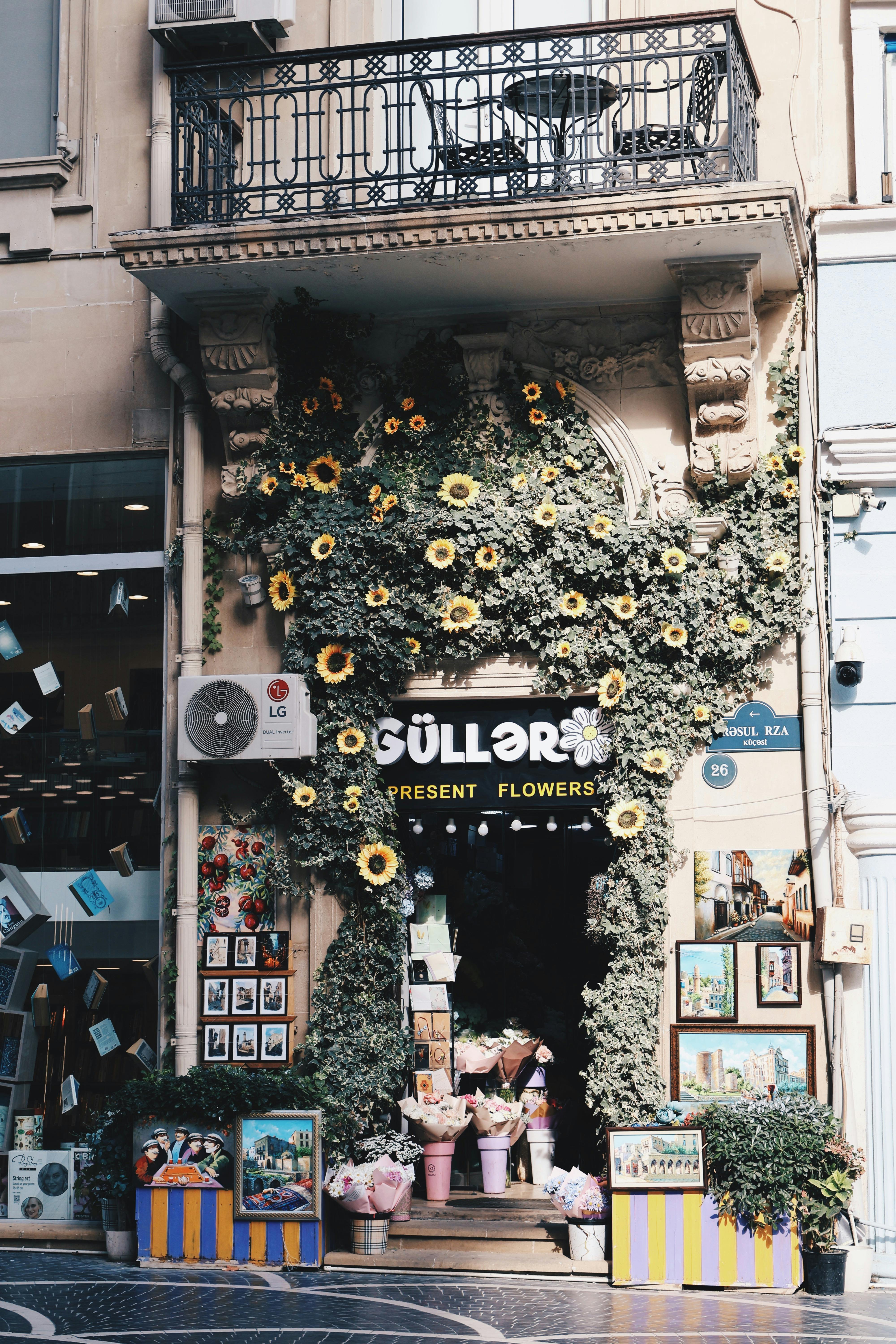Flower shop with sunflower decor and quaint design on a street in Baku, offering a picturesque scene.