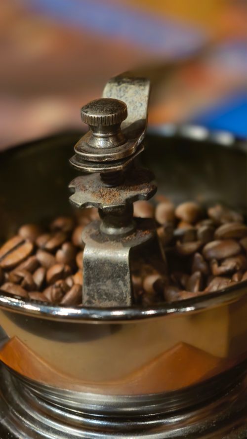 Free Close-up of a vintage coffee grinder filled with coffee beans, highlighting rustic details. Stock Photo