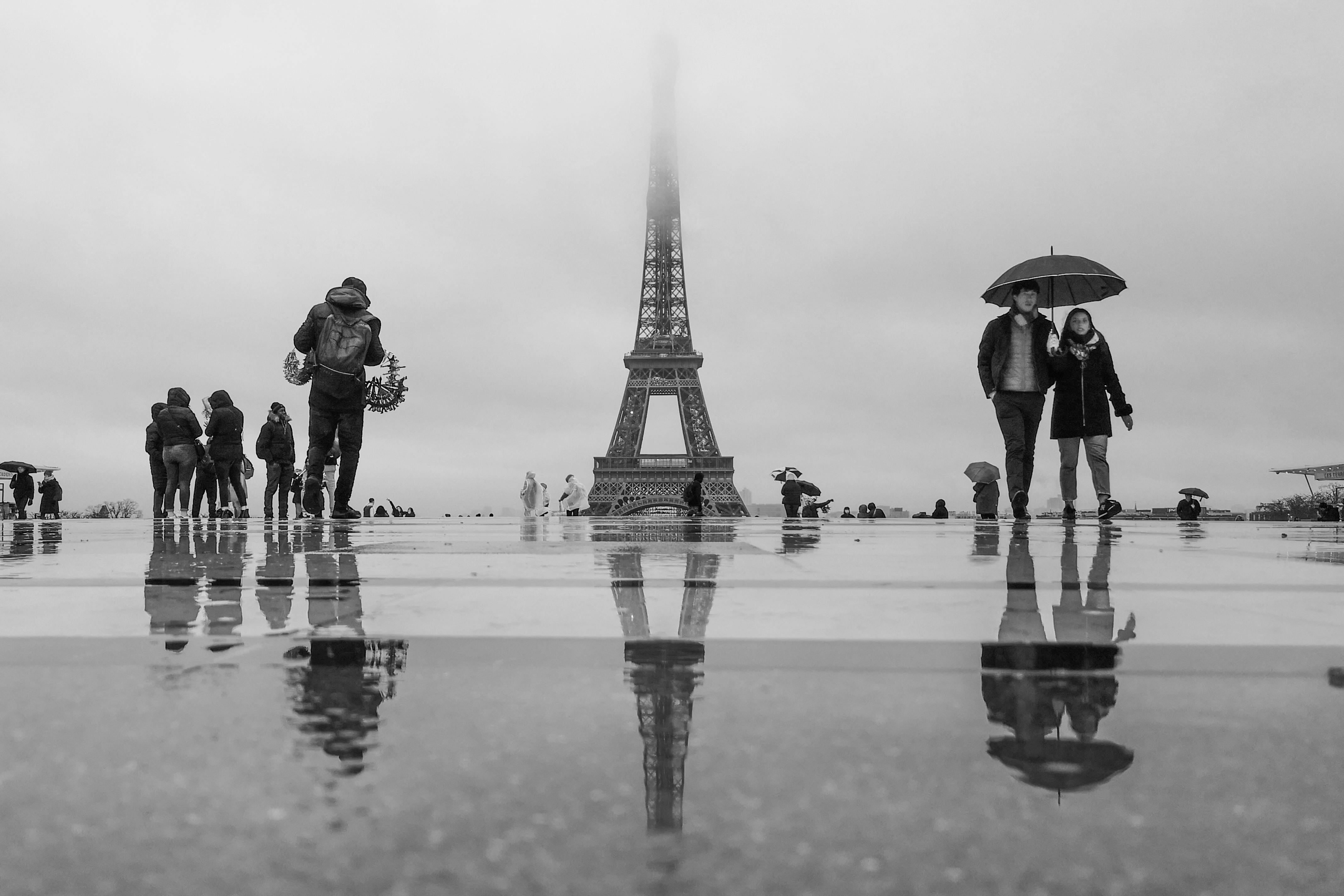 people walking on street behind eiffel tower