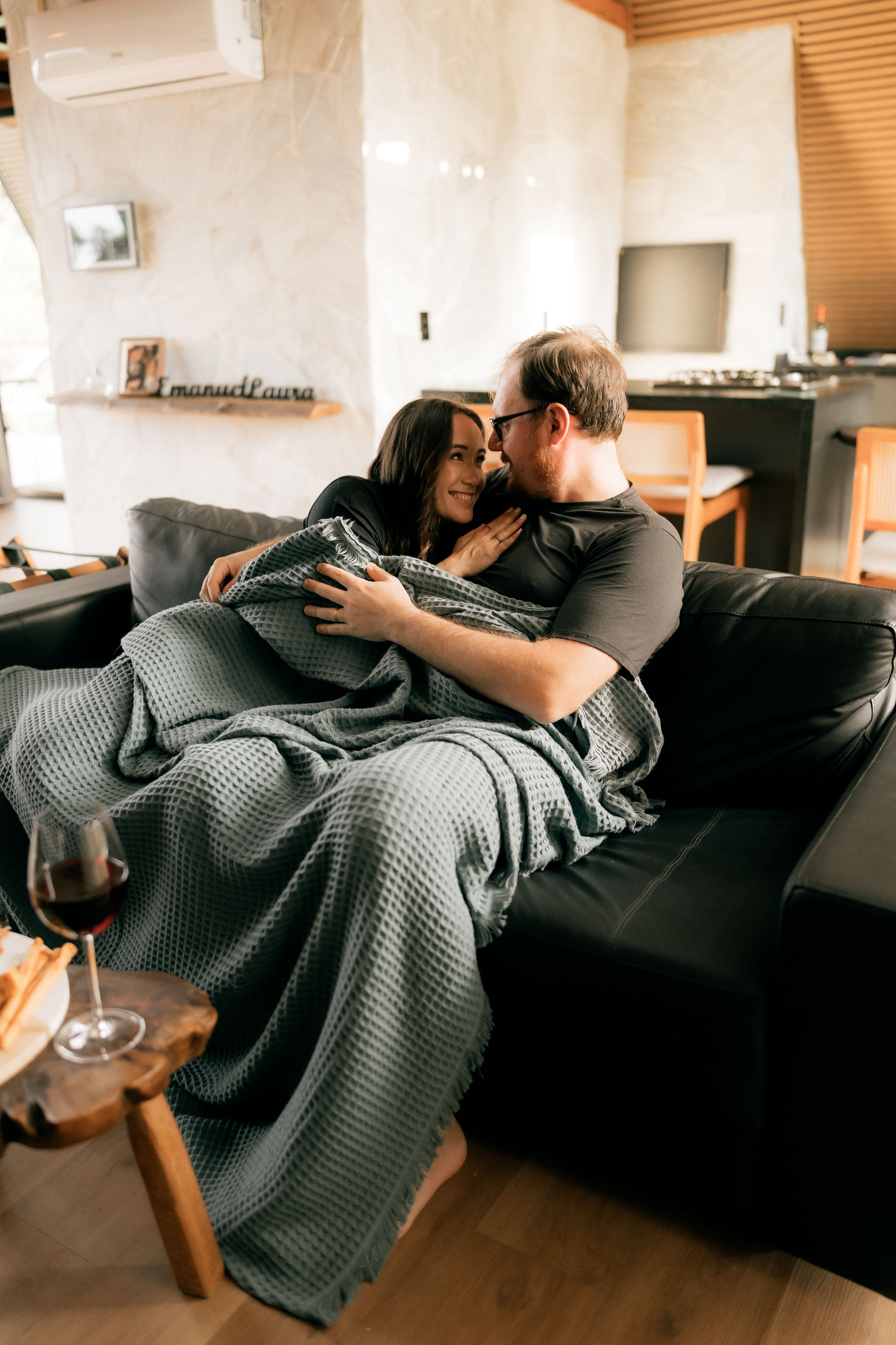 Cozy Couple Relaxing on Sofa with Wine · Free Stock Photo