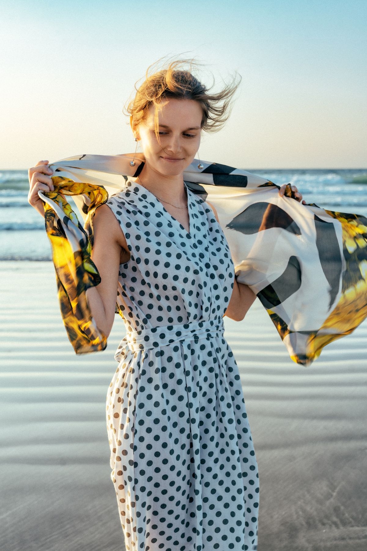 A woman enjoying the beach breeze — the optimistic mood of summer 2026