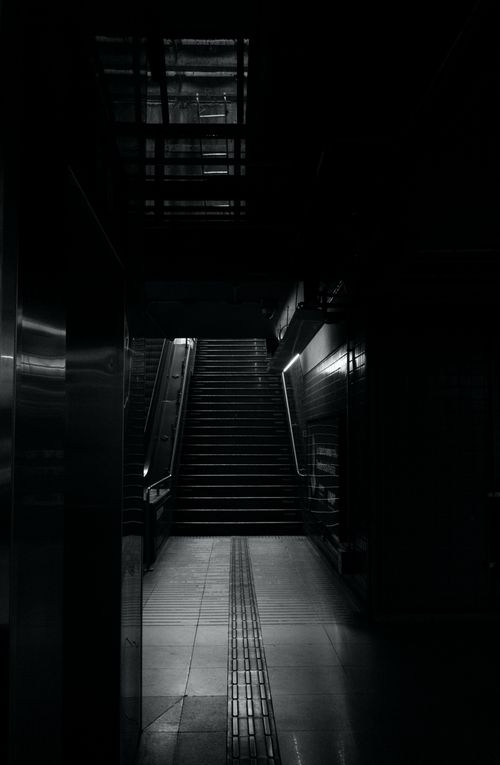 Free Dark, moody empty subway station with illuminated stairs leading up. Stock Photo