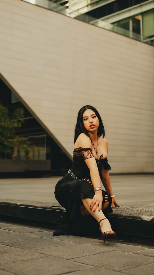 Free Stylish young woman posing urban fashion in an outdoor city setting. Stock Photo
