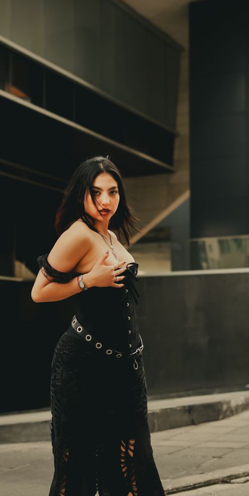 Free Stylish woman in gothic attire poses in an urban environment, exuding confidence and style. Stock Photo