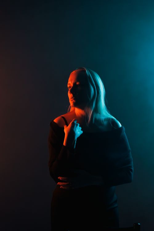 Free Elegant woman's silhouette captured in contrasting warm and cool lighting. Stock Photo