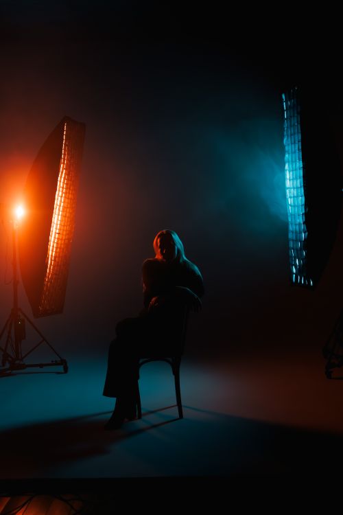 Free Studio portrait with vivid blue and orange lights casting dramatic shadows. Stock Photo