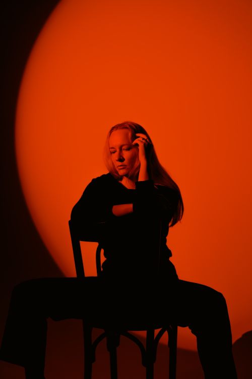 Free Artistic portrait of a woman in silhouette against a striking red background. Stock Photo