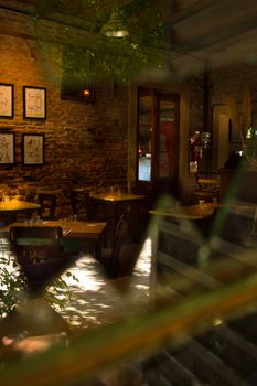 Warm, rustic cafe interior with brick walls, wooden tables, and artwork.
