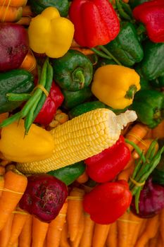 Vibrant display of fresh vegetables including corn, peppers, and carrots.