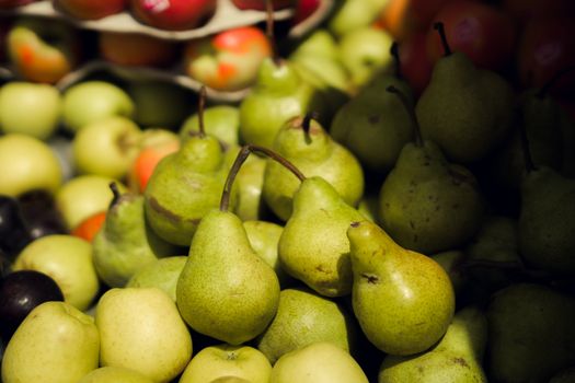 Vibrant green pears and apples displayed at a farmers' market.