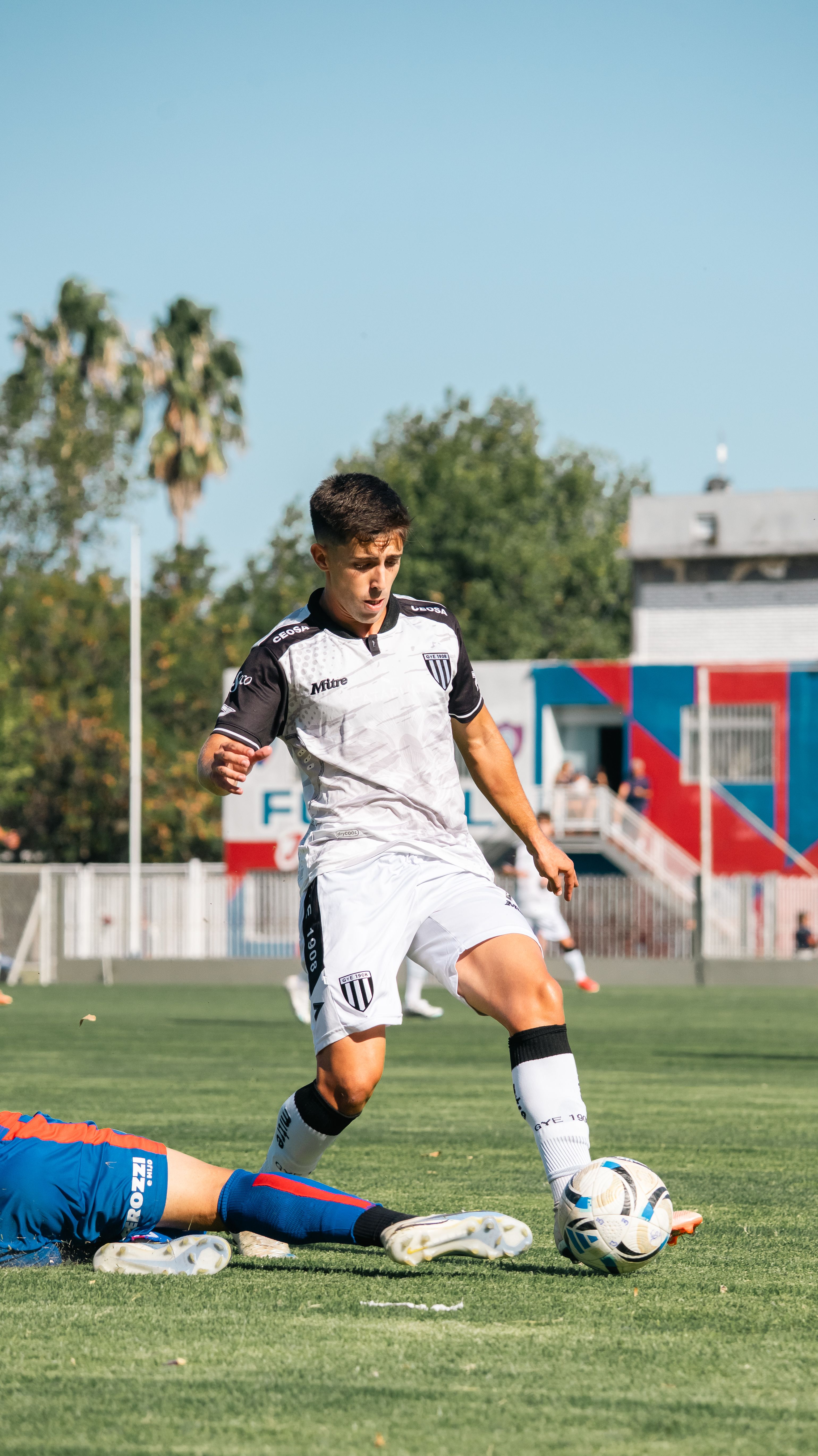 A dynamic soccer game featuring young athletes in action on a sunny day.