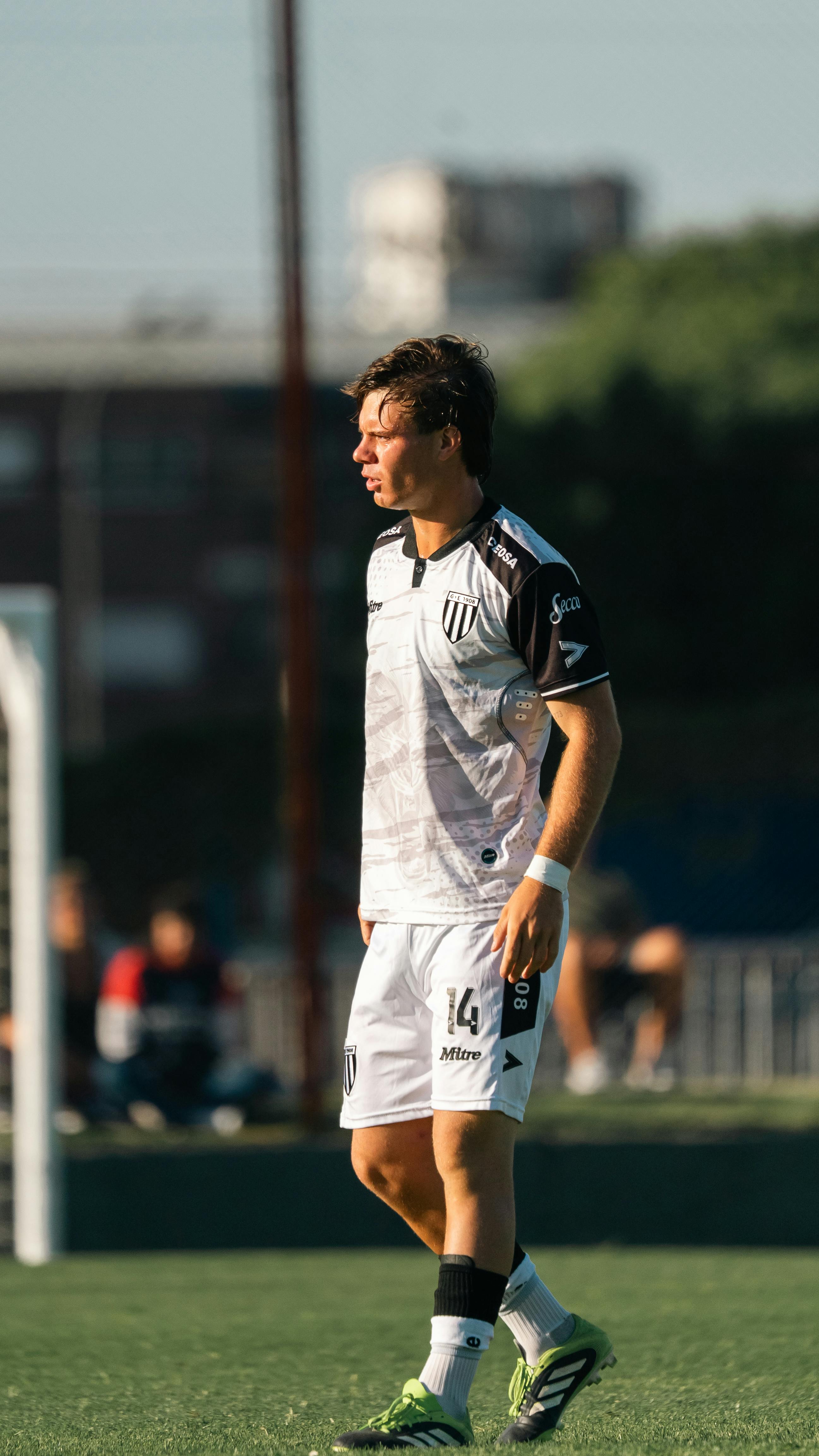 Action shot of a male soccer player during a daytime game on an outdoor field.