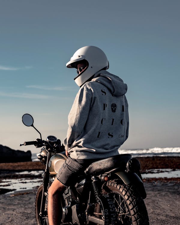 오토바이를 타고 흰색 헬멧을 착용하는 사람