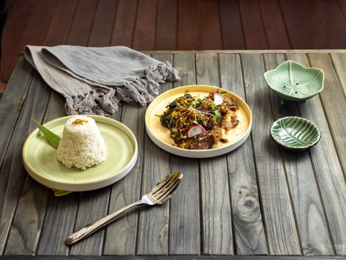 Free Delicious traditional Indonesian meal with rice and vegetables on a rustic wooden table setting. Stock Photo