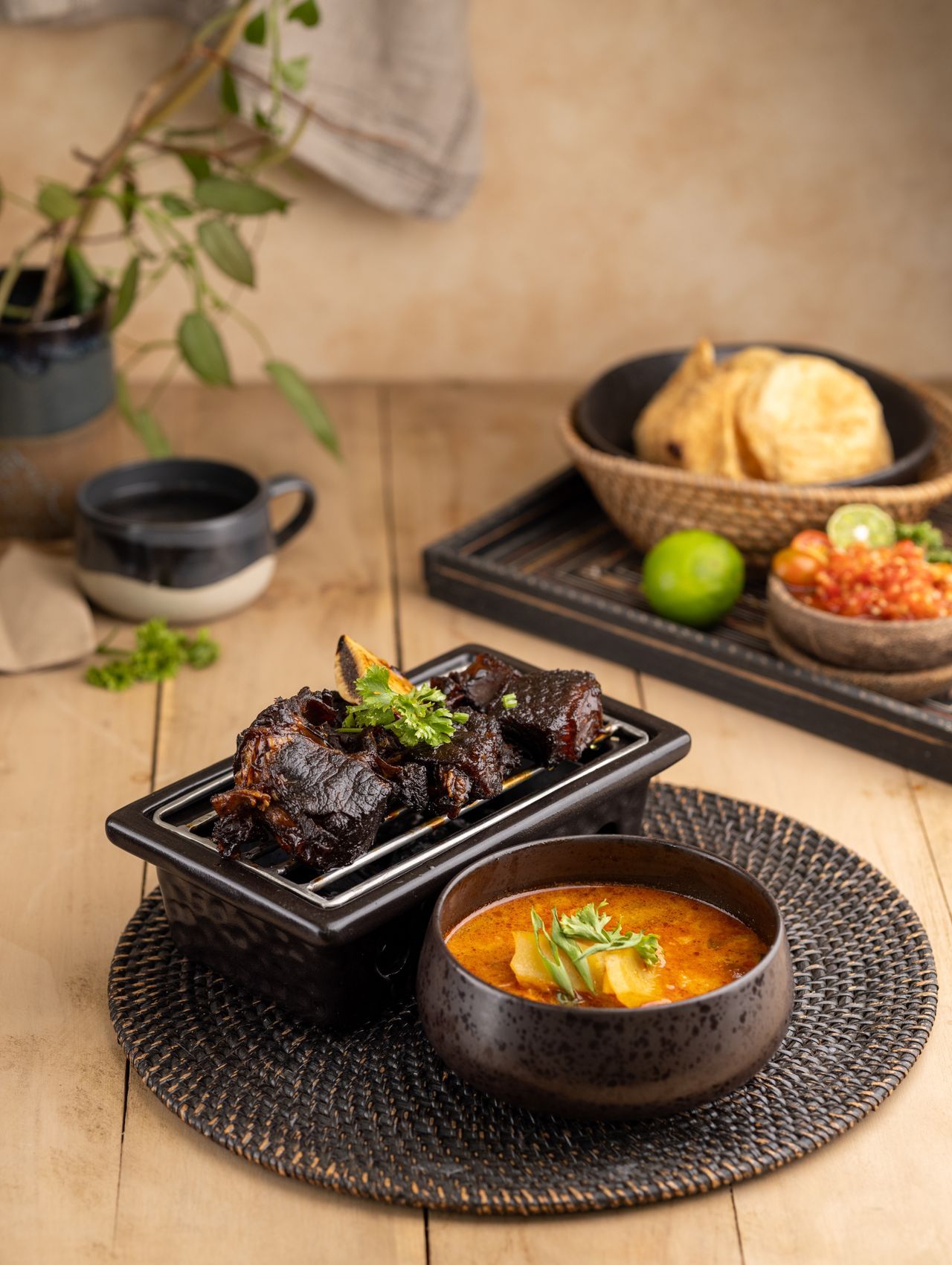 Traditional Mexican birria tacos served with flavorful red consommé on a rustic plate