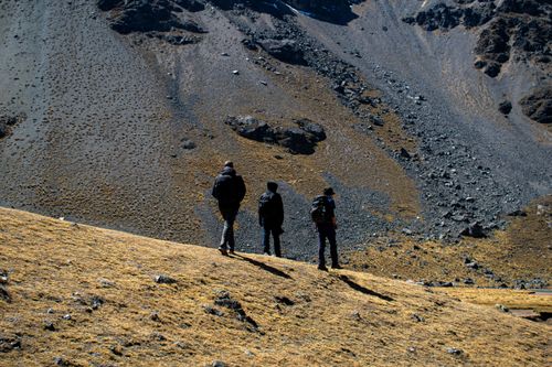 Free Three hikers explore a rocky landscape in Cusco, Peru, under clear blue skies. Stock Photo
