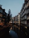 傍晚时分，阿姆斯特丹运河风景如画，历史建筑与柔和的倒影相映成趣
