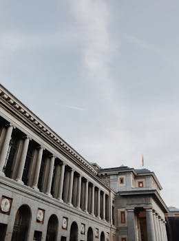 A stunning view of the Prado Museum in Madrid against a clear blue sky, showcasing classic architecture.