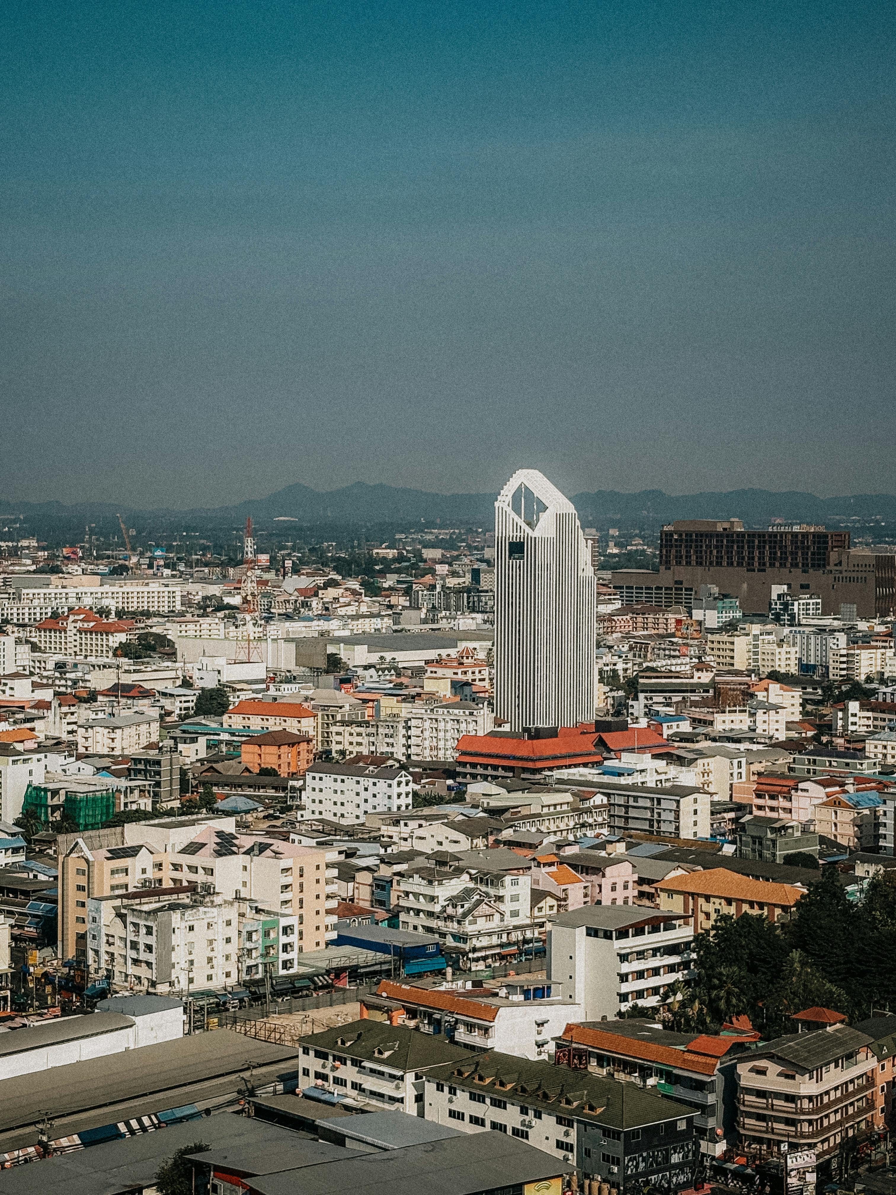 Discover the urban landscape of Pattaya City, highlighting a distinctive skyscraper amidst the bustling environment.